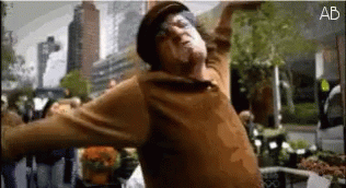 Man in Brown Sweater Hat Dancing Before Crowd