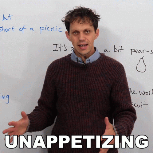 Man in Brown Sweater in Front of White Board With Unappetizing