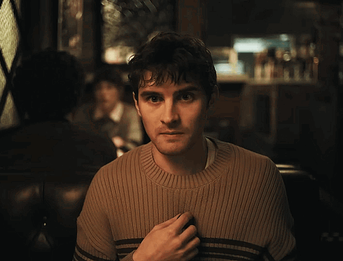 Man in Brown Sweater Looking at Camera