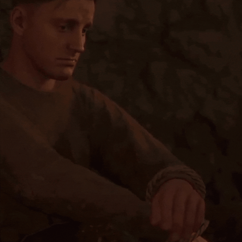 Man In Brown Sweater Sitting In Dark Room Checking Watch GIF