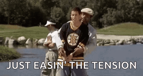 Man in Bruins Jersey Helped by Man in Golf Shirt