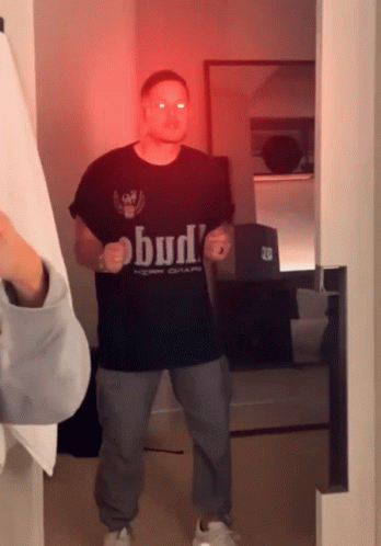 Man in Bud T-Shirt Standing in Room