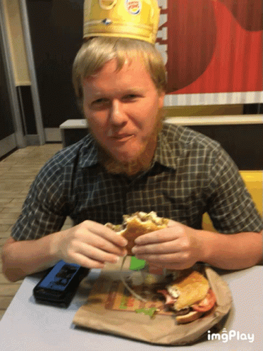 Man in Burger King Crown Eating Hamburger