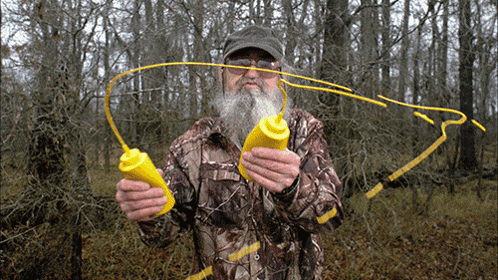 Man in Camo Jacket Holding Two Yellow Bottles