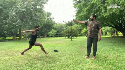 Man In Camo Shirt Throwing Frisbee Another Man Watches GIF