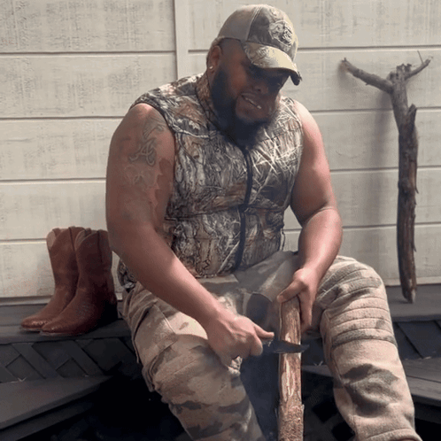 Man In Camo Vest Cutting Log GIF
