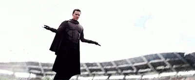 Man in Cape Standing at Stadium