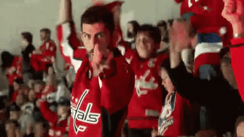 Man in Capitals Jersey Pointing at Cheering Crowd