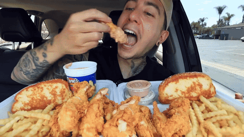 Man in Car Eating Fried Chicken and French Fries
