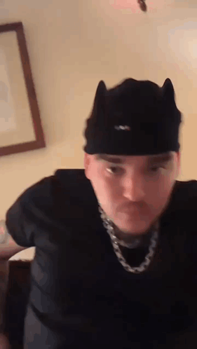 Man in Cat Ear Hat and Chain Making Funny Face