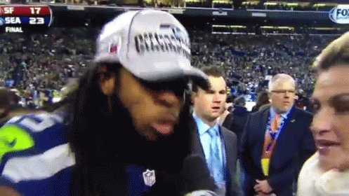 Man in Champions Hat Talking Into Microphone