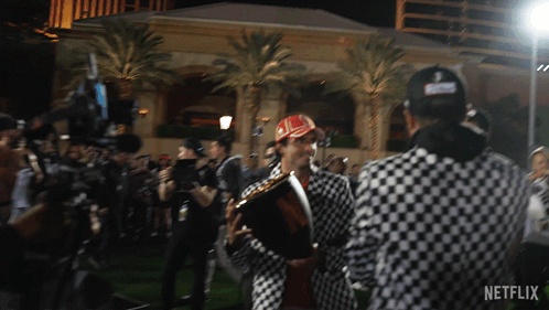 Man in Checkered Jacket Holding Trophy