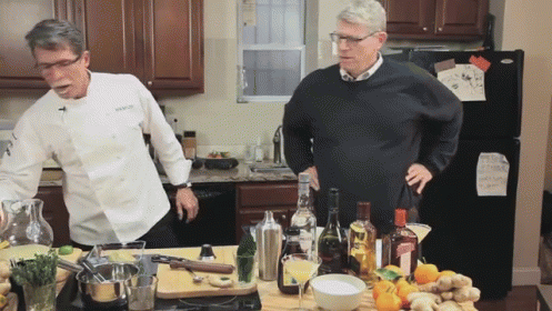 Man in Chef Jacket Next to Man in Sweater