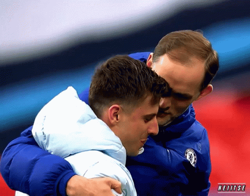 Man In Chelsea Jacket Hugging Man In Blue Jacket GIF