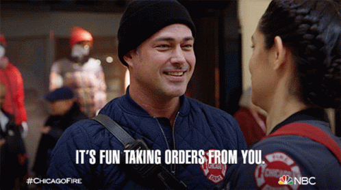 Man In Chicago Fire Department Jacket Talking To Woman GIF