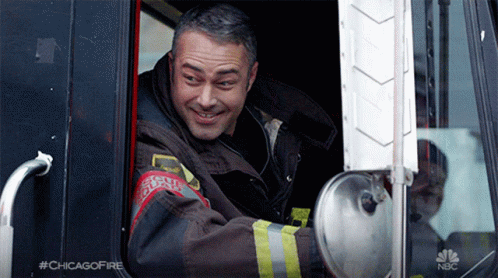 Man in Chicago Fire Uniform Smiling in Truck