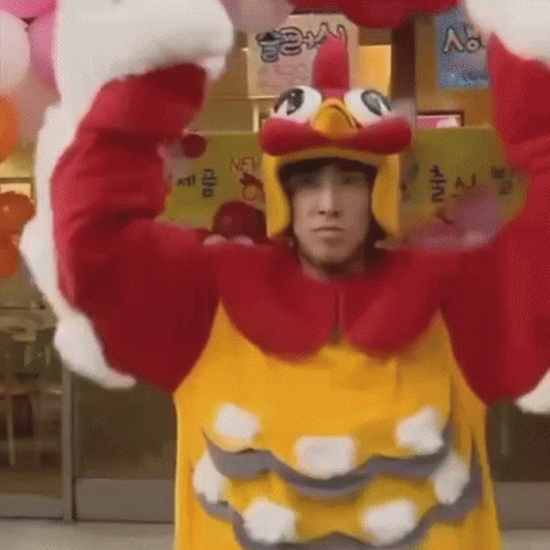 Man In Chicken Costume Holding Balloons In Front Of Store GIF