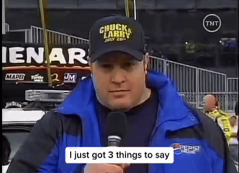 Man in Chuck Larry Hat Talking Into Microphone