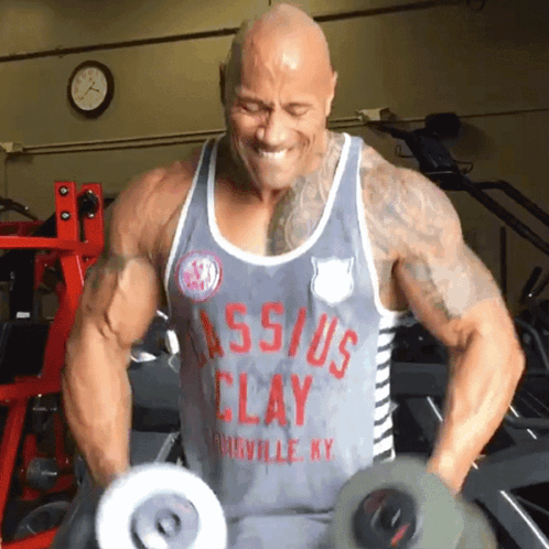 Man In Clay Tank Top Lifting Dumbbells GIF
