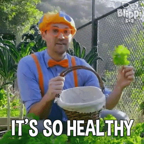 Man in Clown Costume Holding Basket of Lettuce
