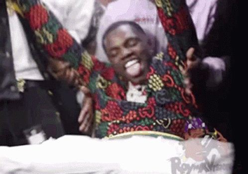 Man in Colorful Jacket Lying on Bed With Arms Outstretched