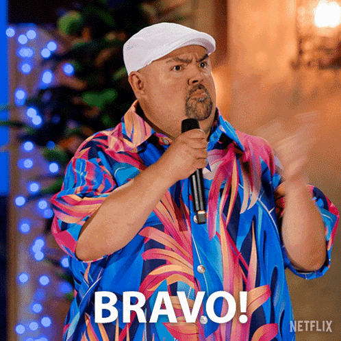 Man in Colorful Shirt Holding Microphone With Bravo Above