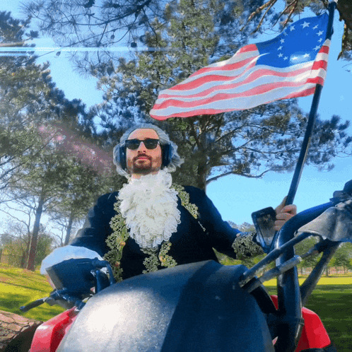 Man In Costume Holding American Flag Riding Golf Cart GIF