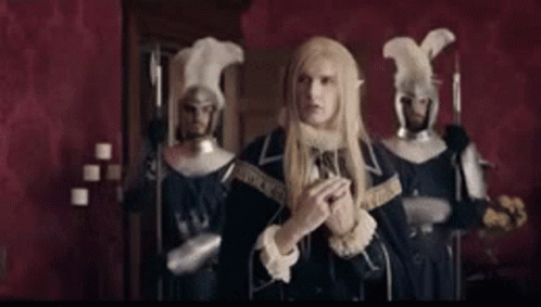 Man In Costume Standing Before Armored Men GIF