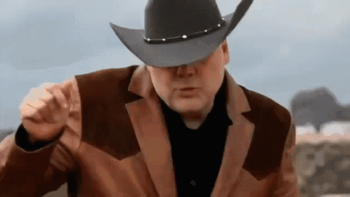 Man in Cowboy Hat and Brown Jacket Pointing