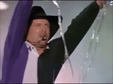 Man In Cowboy Hat And Purple Jacket Holding Rope GIF