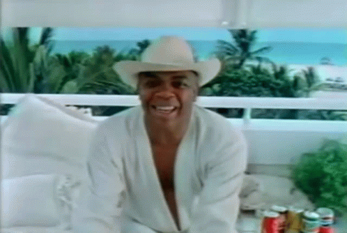 Man in Cowboy Hat and Robe Sitting on Balcony