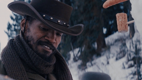 Man in Cowboy Hat and Scarf With Hot Dogs Flying
