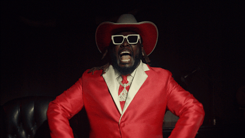 Man In Cowboy Hat And Sunglasses Holding Guns GIF