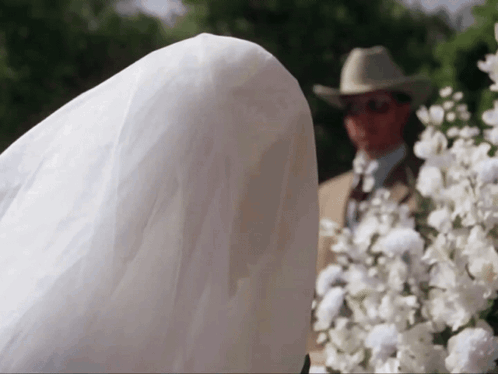 Man in Cowboy Hat Behind Bride in White Dress