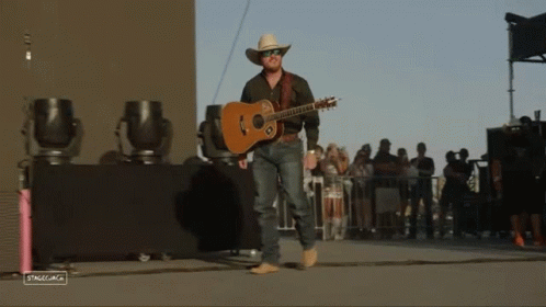 Man in Cowboy Hat Holding Guitar