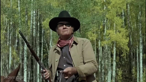 Man in Cowboy Hat Holding Gun Forest movieclips.com