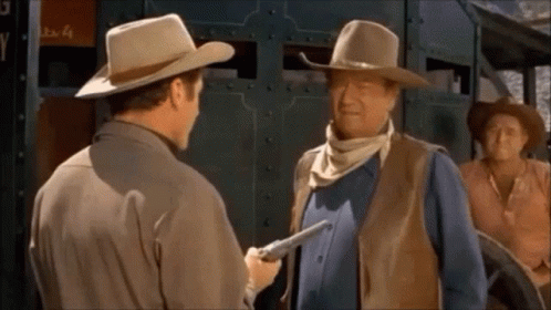 Man in Cowboy Hat Holding Gun to Another Man's Chest