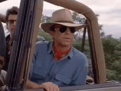 Man In Cowboy Hat Lying On Dinosaur GIF