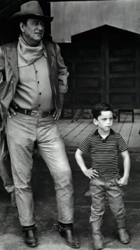 Man in Cowboy Hat Next to Young Boy