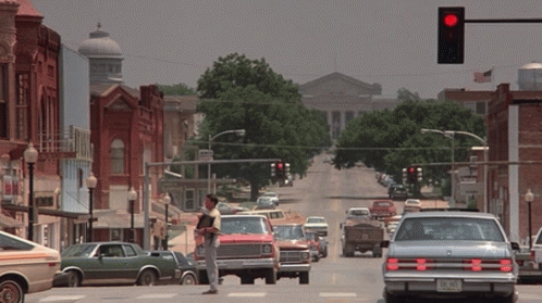 Man in Cowboy Hat on Busy Street with Red Light
