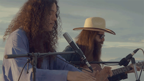 Man in Cowboy Hat Playing Guitar and Singing