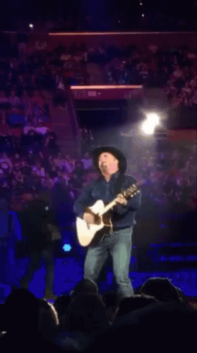 Man In Cowboy Hat Playing Guitar For Crowd GIF