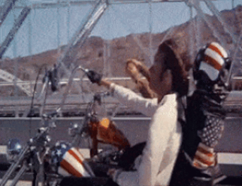 Man in Cowboy Hat Riding Motorcycle With American Flag