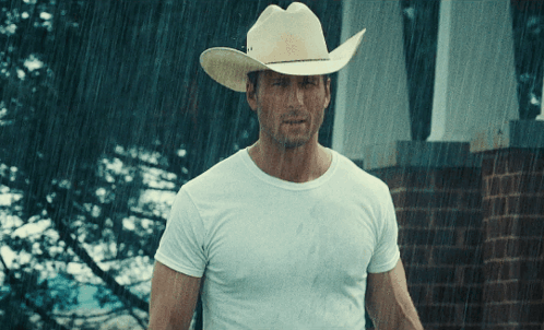 Man In Cowboy Hat Stands In Rain GIF