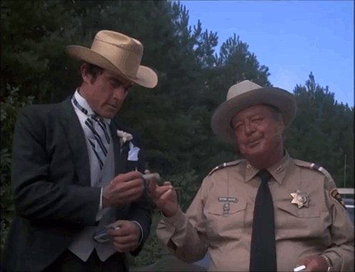Man In Cowboy Hat Talking To Man In Suit GIF