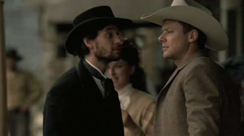 Man in Cowboy Hat Talking to Suit