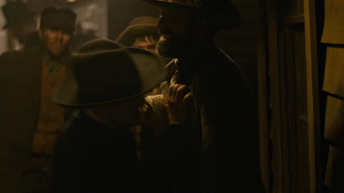 Man in Cowboy Hat Talking to Suit