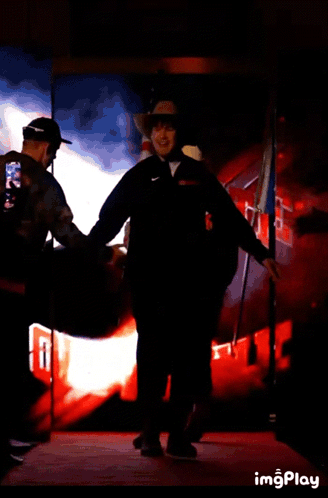 Man In Cowboy Hat Walking With American Flag GIF
