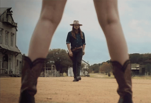 Man in Cowboy Hat Walking With Woman in Cowboy Boots