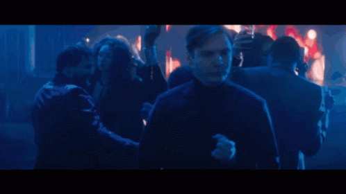Man In Crowd In Dark Room GIF